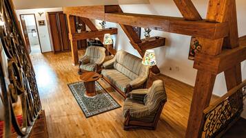 Un loft amplio con vigas de madera, un conjunto de sofás y una pequeña mesa.