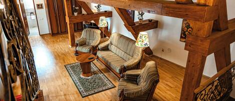 A spacious loft with wooden beams, a sofa set, and a small table.