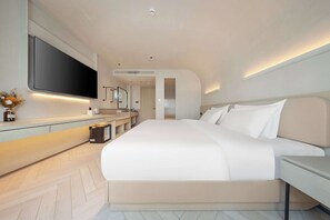 Quarto moderno com uma cama grande, televisão de tela plana na parede e design minimalista.