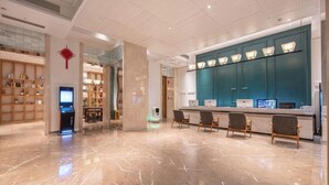A modern lobby with a reception desk, seating area, and a digital kiosk. - World Hotel Hexie Plaza branch (Jinan)