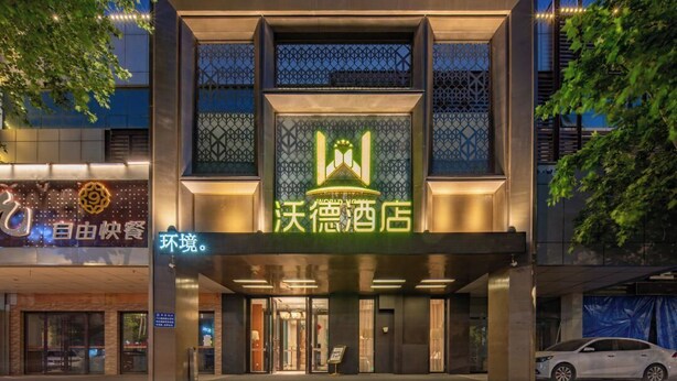 A hotel with a modern facade, featuring a prominent logo and signage in a foreign language. - World Hotel Hexie Plaza branch (Jinan)