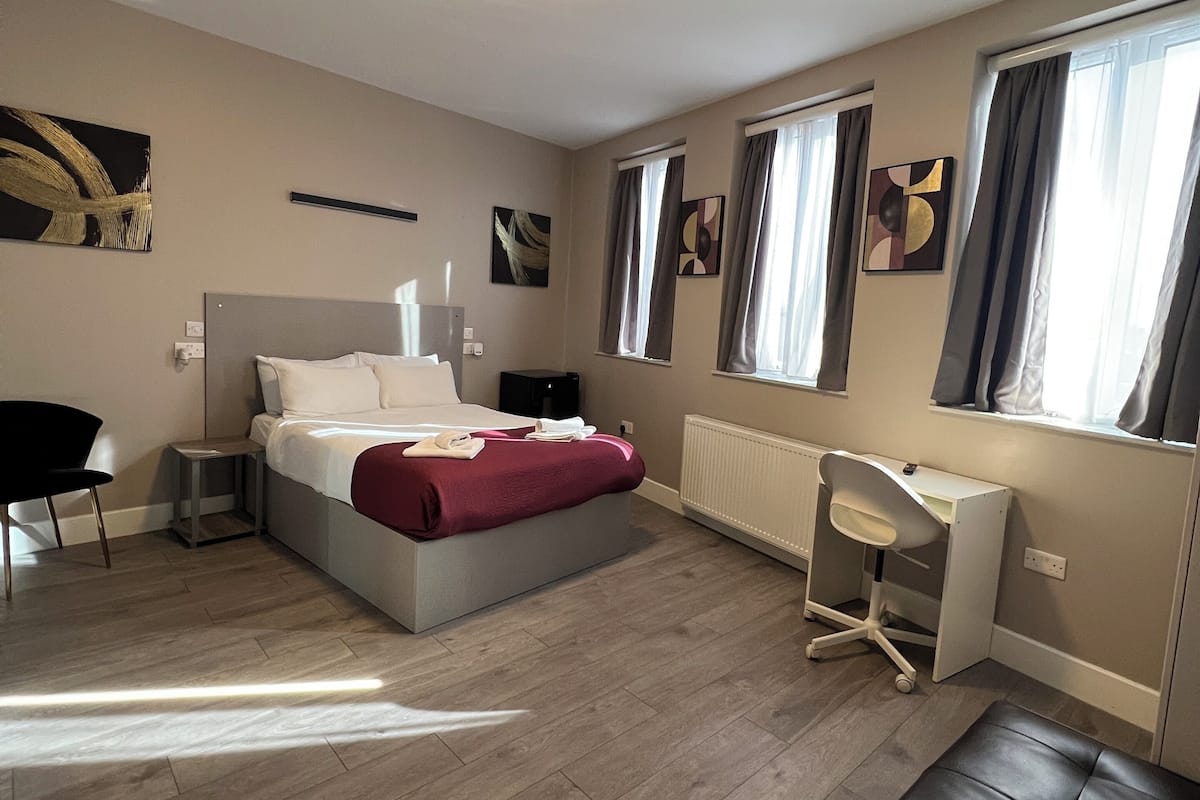 Relax in a spacious room with a large bed, desk, and comfortable seating area.