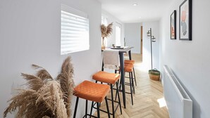 A modern kitchen with white cabinets, a black countertop, and a hanging light fixture. - Host Stay Mayfield (Harrogate)