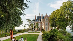 A historic building with a well-maintained garden and a dining area with outdoor seating. - Les Hauts de Sancerre   (Sancerre)