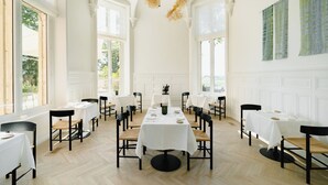 A spacious dining hall with high ceilings, large windows, and a central table surrounded by chairs. - Les Hauts de Sancerre   (Sancerre)