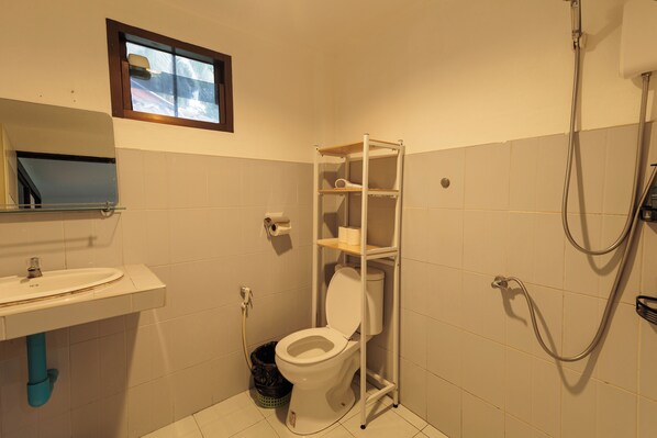 A small bathroom with a toilet, a sink, and a shower.