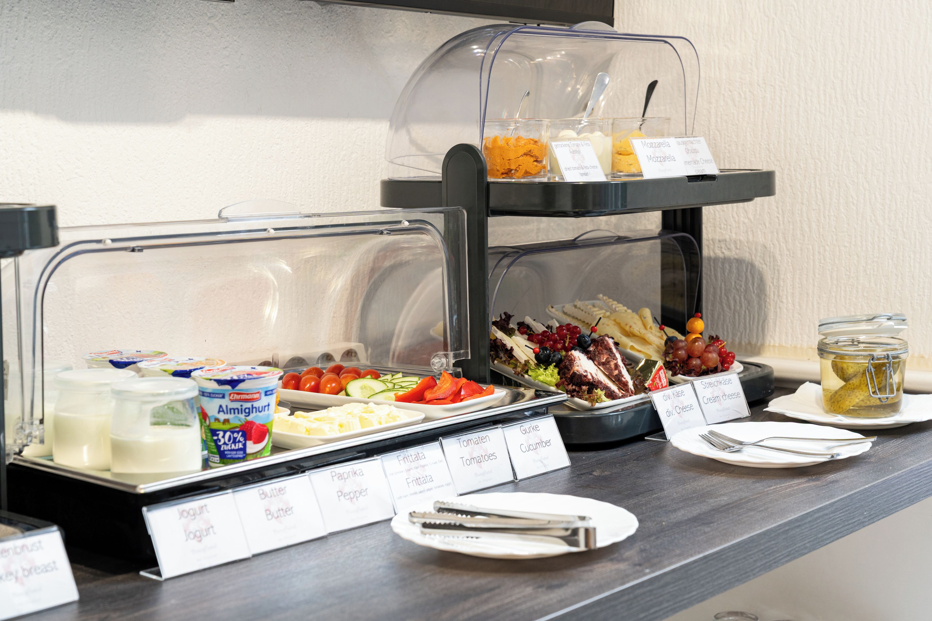 Un buffet proposant une variété d’aliments, notamment du yaourt, du beurre et du fromage.