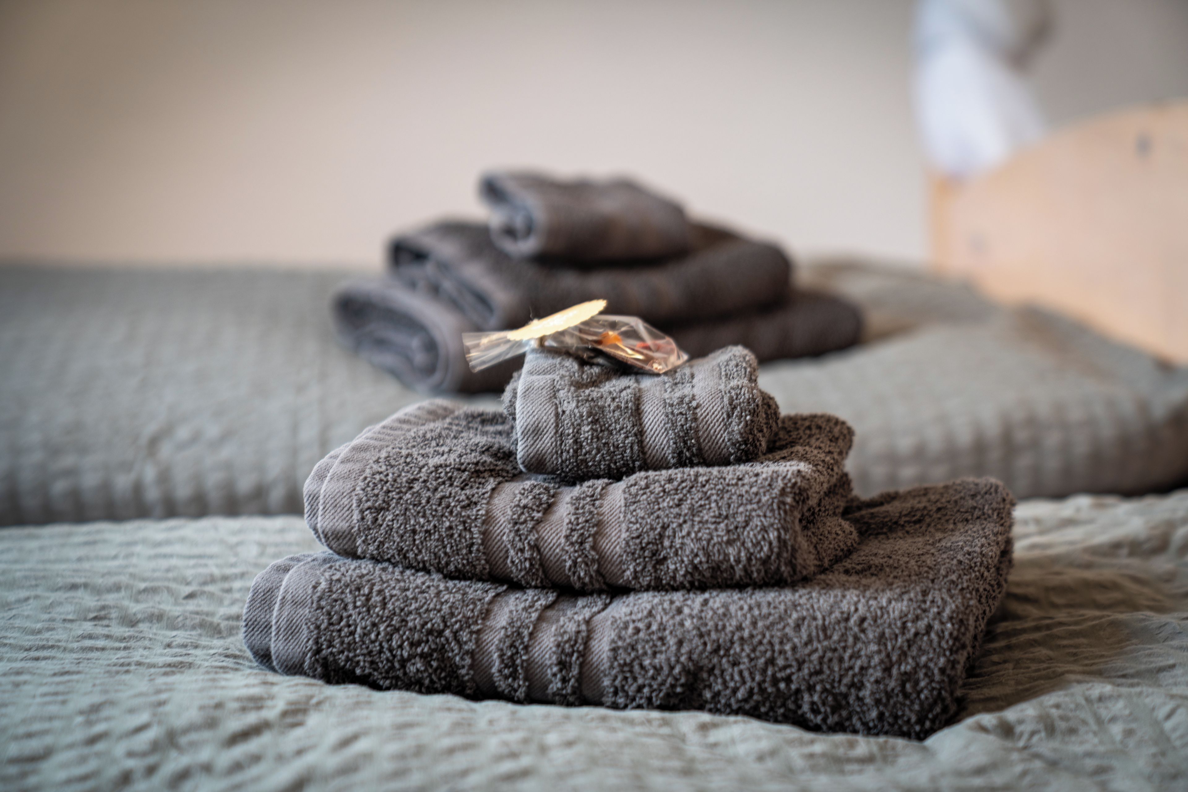 A bed with folded blankets and a small item on top.