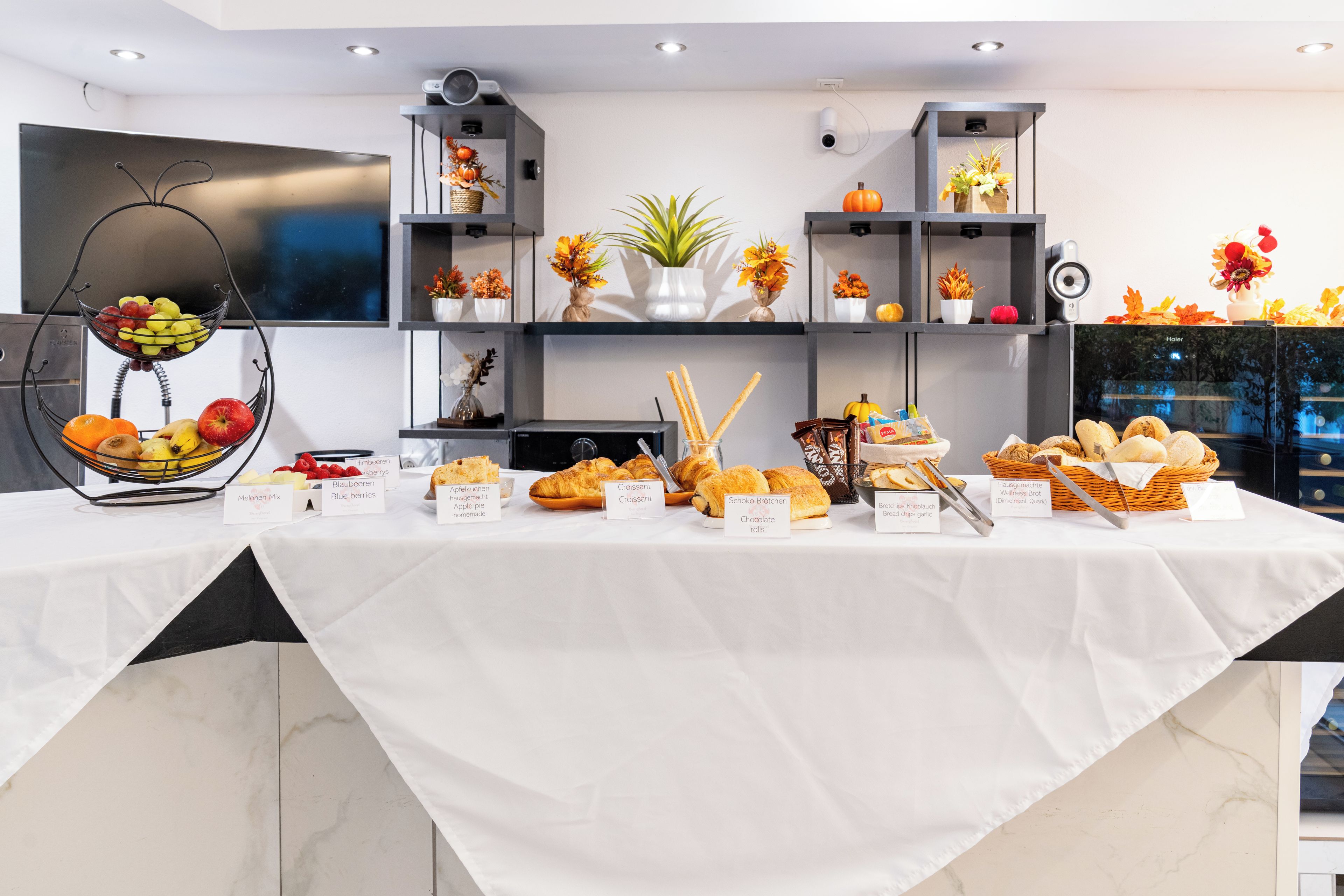A buffet table with various food items and a clock on the wall.