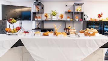 A buffet table with various food items and a clock on the wall.