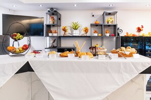 A buffet table with various food items and a clock on the wall. - Burghotel - das Original (Nuremberg)
