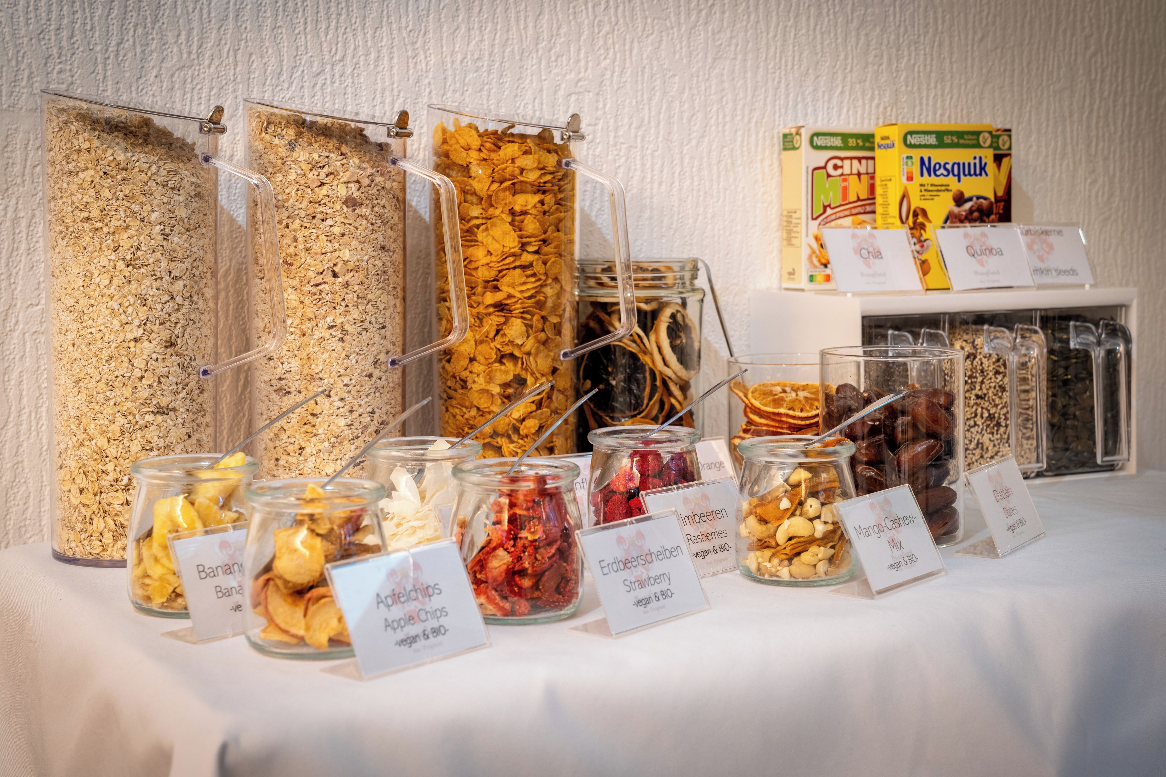 A buffet with various food options including cereals, dried fruits, and nuts.