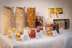 Un bufé con diversas opciones de comida, incluyendo cereales, frutas secas y nueces.