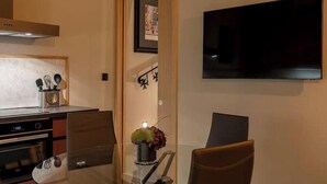 A modern kitchen with a stove, oven, and a dining area with a chair and a table. - Zekka House (Valletta)
