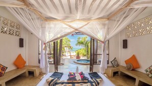 Une chambre avec un lit, des bancs et une vue sur une piscine et un espace verdoyant.