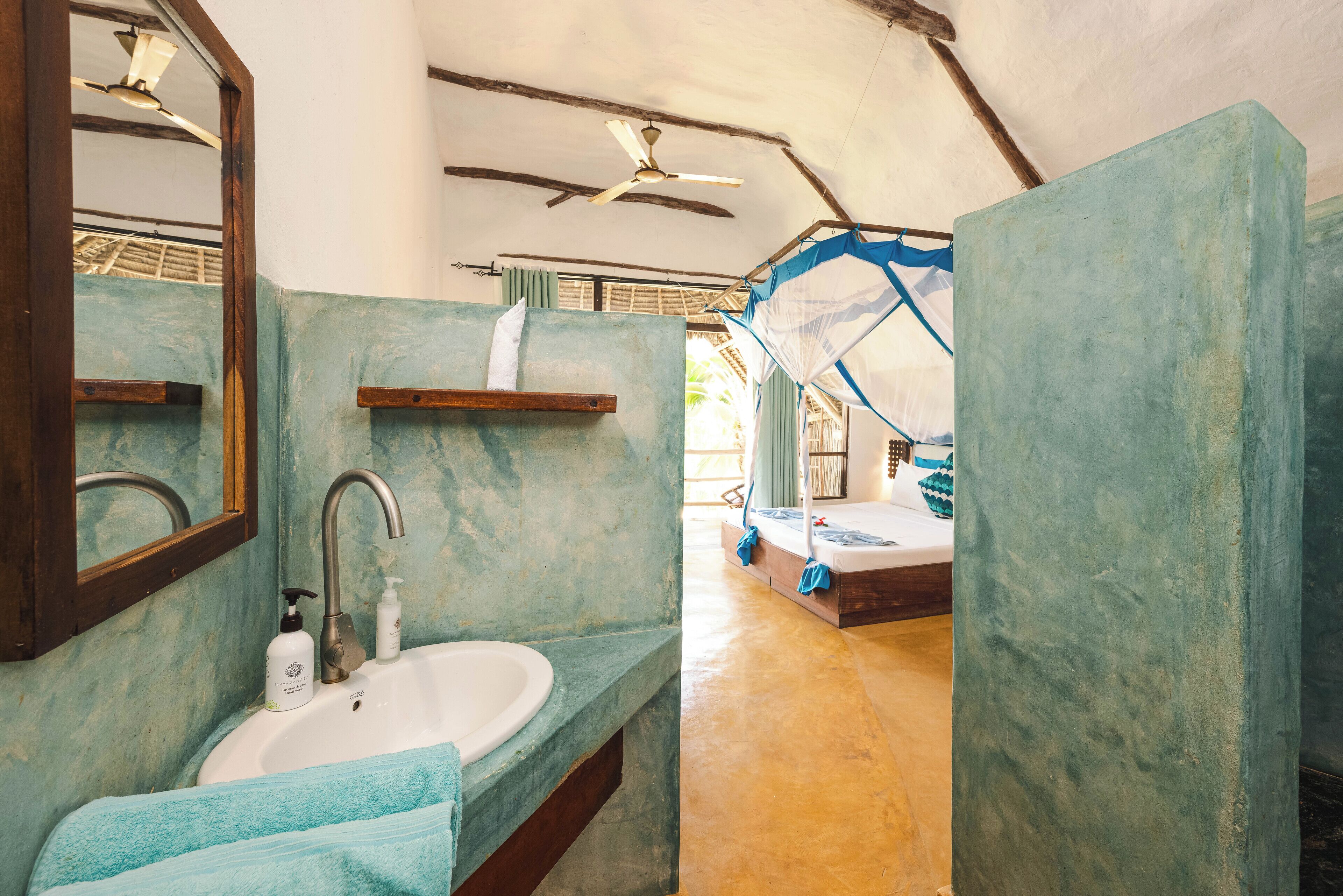A bathroom with a sink, mirror, and ceiling fan.