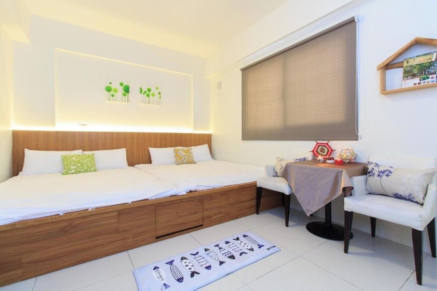 Une chambre moderne avec un grand lit, des tables de chevet, un petit canapé et une fenêtre avec un store.