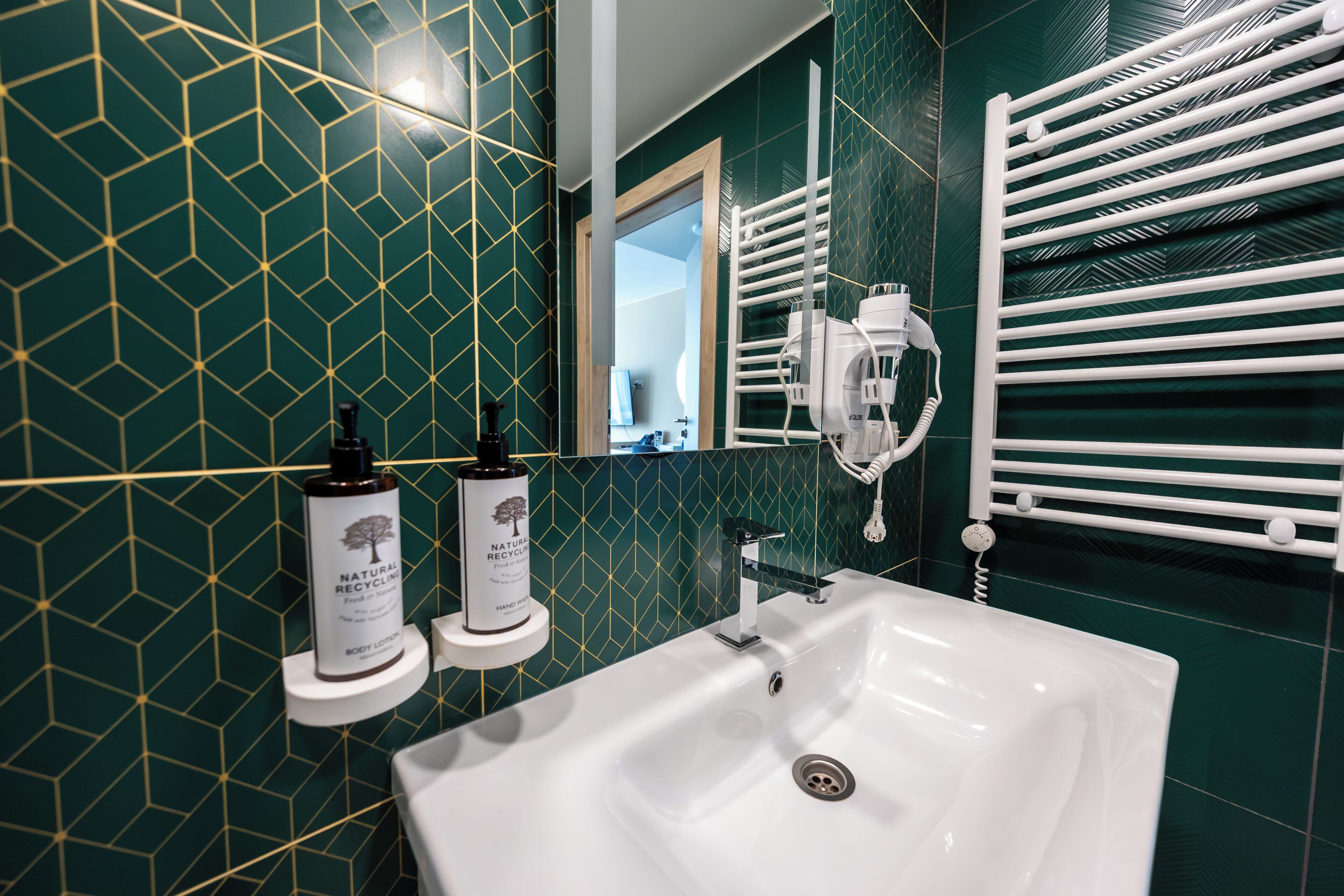 A bathroom with a white sink, a mirror, and a towel rack.