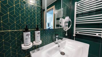 A bathroom with a white sink, a mirror, and a towel rack.
