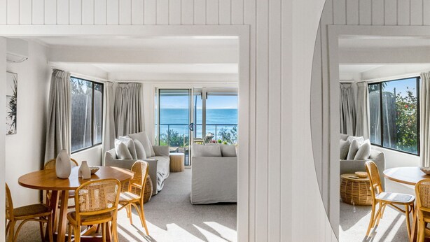 Ein modernes Interieur mit Essbereich, Sofas und Meerblick.