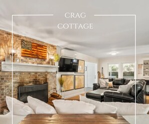 A cozy living room with a fireplace, a television, and a comfortable seating area. - Adventure cottage in Gingercake (Newland)