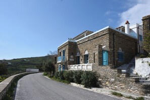 Un bâtiment en pierre avec une route sinueuse devant.