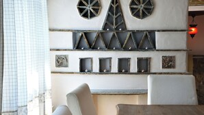 Une pièce dont les murs sont décorés dans un style rustique, avec des motifs géométriques et des supports pour bougies.