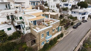 Un immeuble résidentiel doté d’une terrasse sur le toit, de murs en pierre et donnant sur la rue.