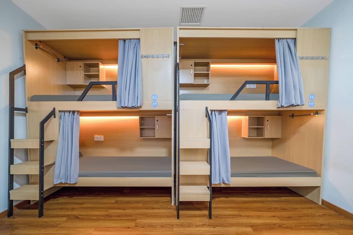 Een slaapkamer met stapelbed, houten wanden, een uitschuifbaar bureau en een klein plankje.