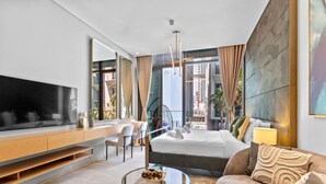 A modern hotel room with a large TV, a bed, a desk, and a balcony with a view of the city. - Vibrant & Exclusive Pool View Studio in Autograph (Dubai)
