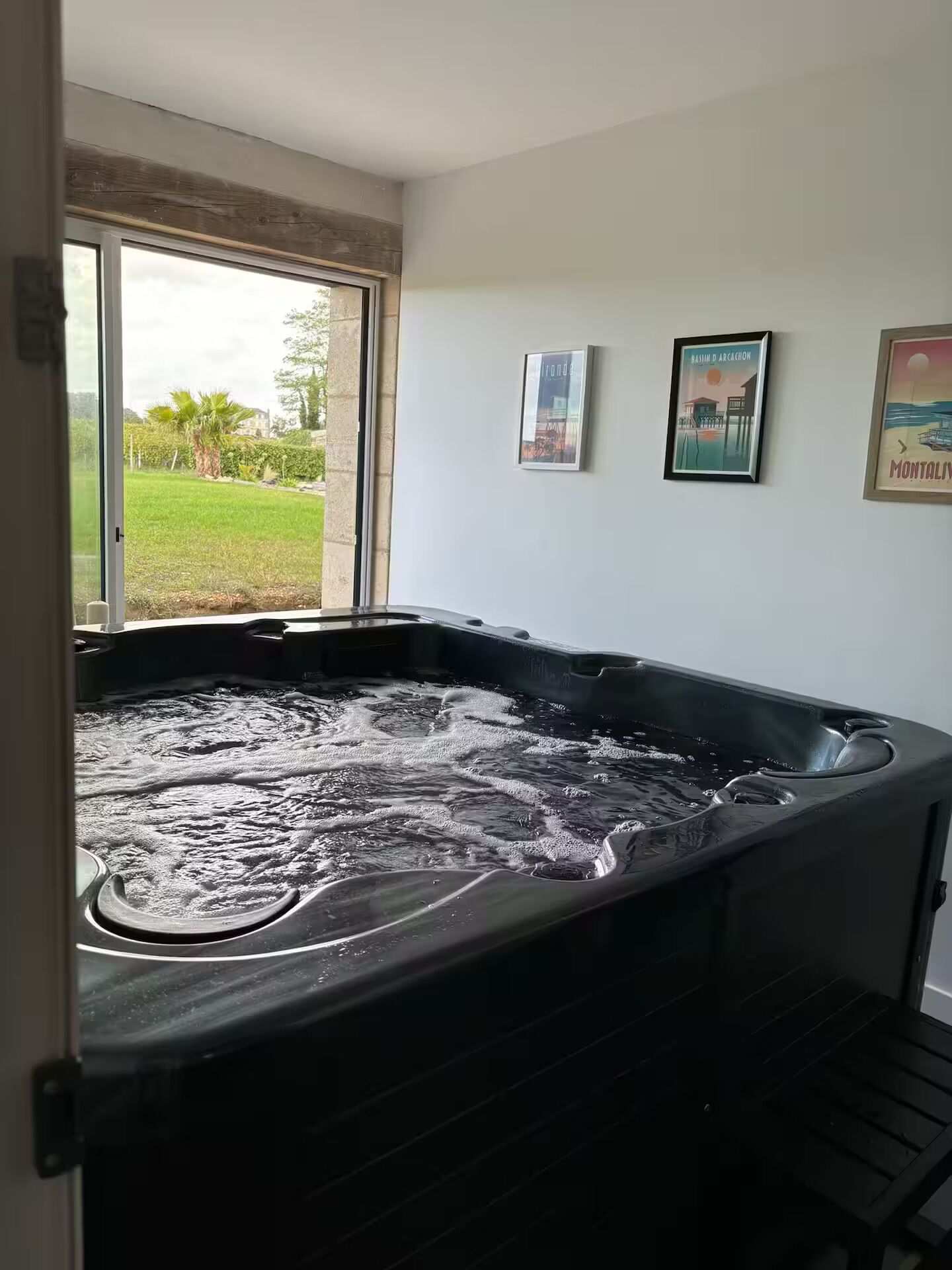 Un jacuzzi con vista a un césped verde y palmeras.