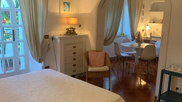 Une chambre dotée d’un grand lit, d’un climatiseur, d’un bureau et d’une chaise.