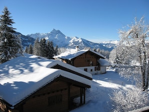 A wooden cabin with a snow-covered roof, surrounded by snow-laden trees and mountains in the background. - The Aigle Royal residence is located not far from the ski lifts that take you to the Gryon - Villars (Gryon)