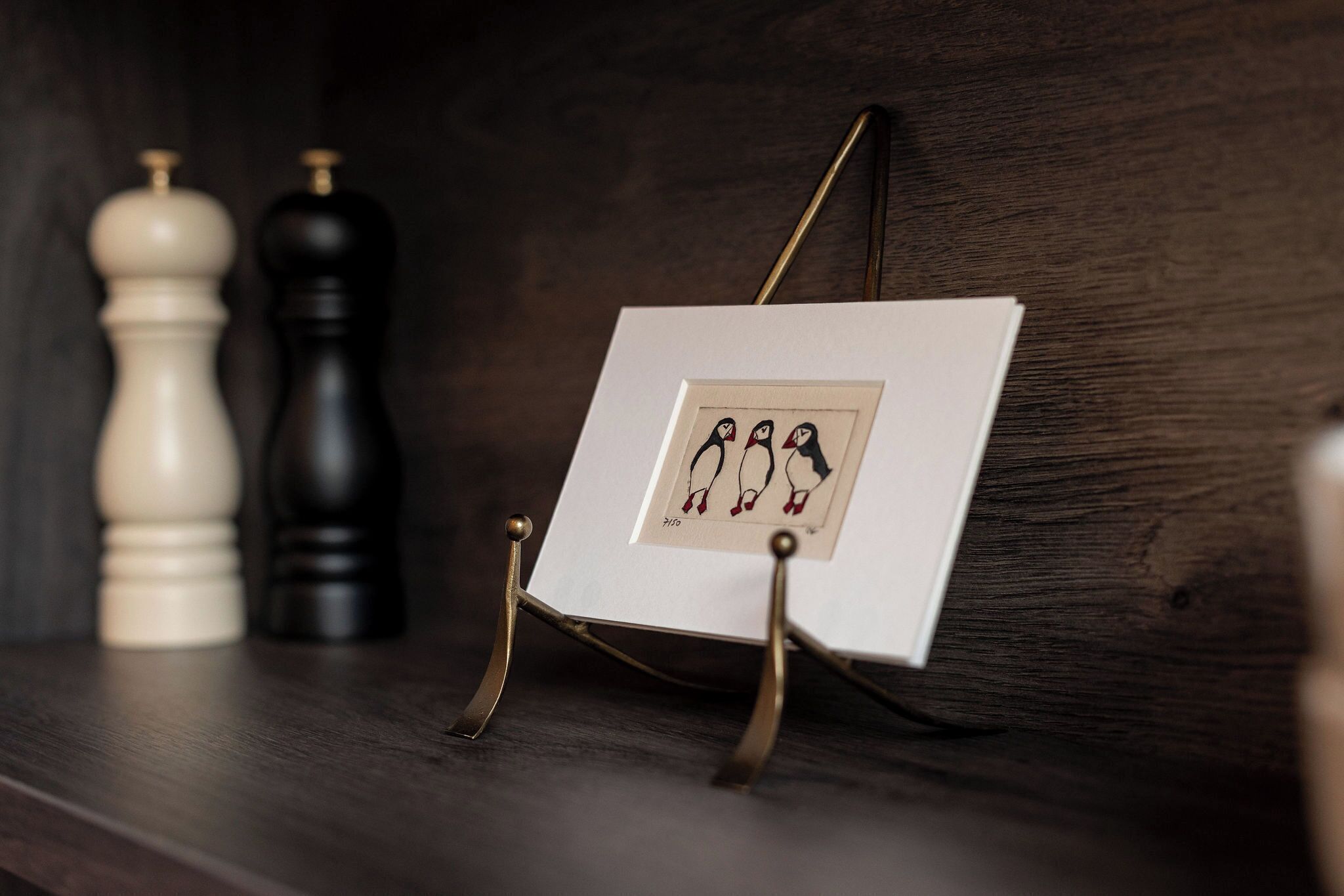 A framed picture on a stand with a dark wooden background.