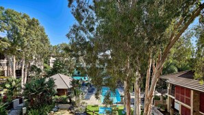 Ein Resort mit Swimmingpool, Liegestühlen und einem tropischen Garten.
