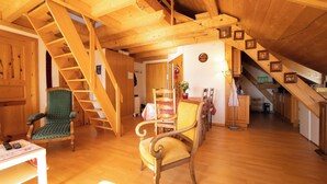 A wooden interior with a staircase, a dining area, and a kitchen.