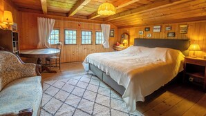 A cozy wooden cabin bedroom with a large bed, a dining table, and a chair. - This beautiful chalet built in 1872 is located in the heart of the pretty village of Gryon. Gryon tr (Gryon)