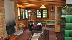A cozy living room with a fireplace, leather sofa, and wooden furniture.