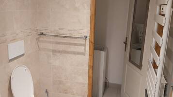 Een douche, een haardroger, handdoeken, toiletpapier