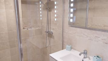 Een douche, een haardroger, handdoeken, toiletpapier