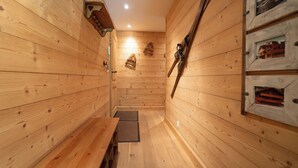 A wooden interior with a bench, wooden walls, and a door.