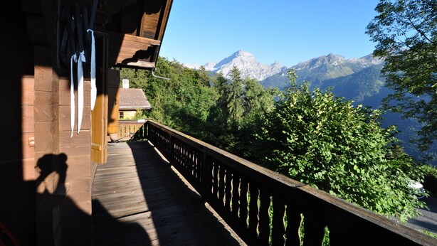 A wooden deck with a view of a mountain range.