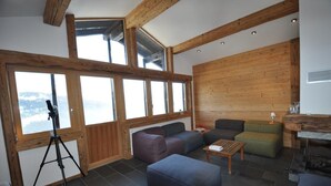 A cozy living room with large windows, wooden beams, a tripod, and a fireplace. - Bright and spacious Chalet Taveyanne, up to 8 people, a few meters from the Villars - Gryon - Diable (Gryon)