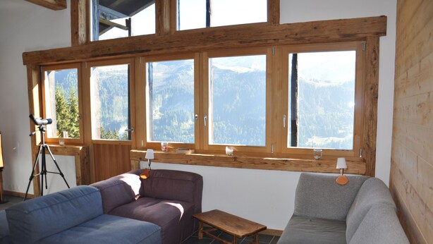 A cozy room with a large window overlooking a mountainous landscape, a purple sofa, a grey sofa, and a small wooden table. - Bright and spacious Chalet Taveyanne, up to 8 people, a few meters from the Villars - Gryon - Diable (Gryon)