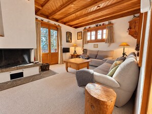 A cozy living room with a fireplace, wooden furniture, and a television.