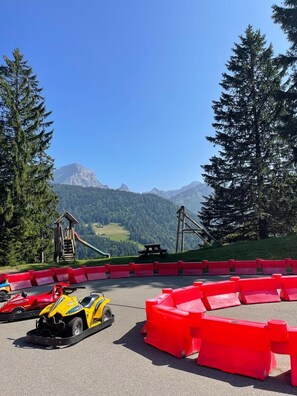 A go-kart track with red barriers, a wooden structure, and a mountain backdrop. - Chalet Tendre est la Nuit - 3 bedrooms - very pretty and cozy chalet just above the village of Gryon (Gryon)