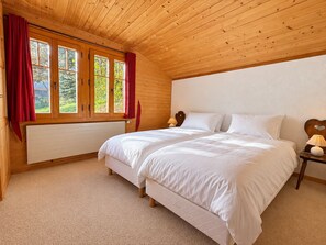 Ein Schlafzimmer mit einem Doppelbett, einem Heizkörper und einem Fenster mit Vorhängen.