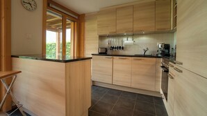 Una cocina moderna con armarios de madera, encimera negra y estufa integrada.