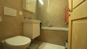 Un baño con inodoro, lavamanos y ducha.