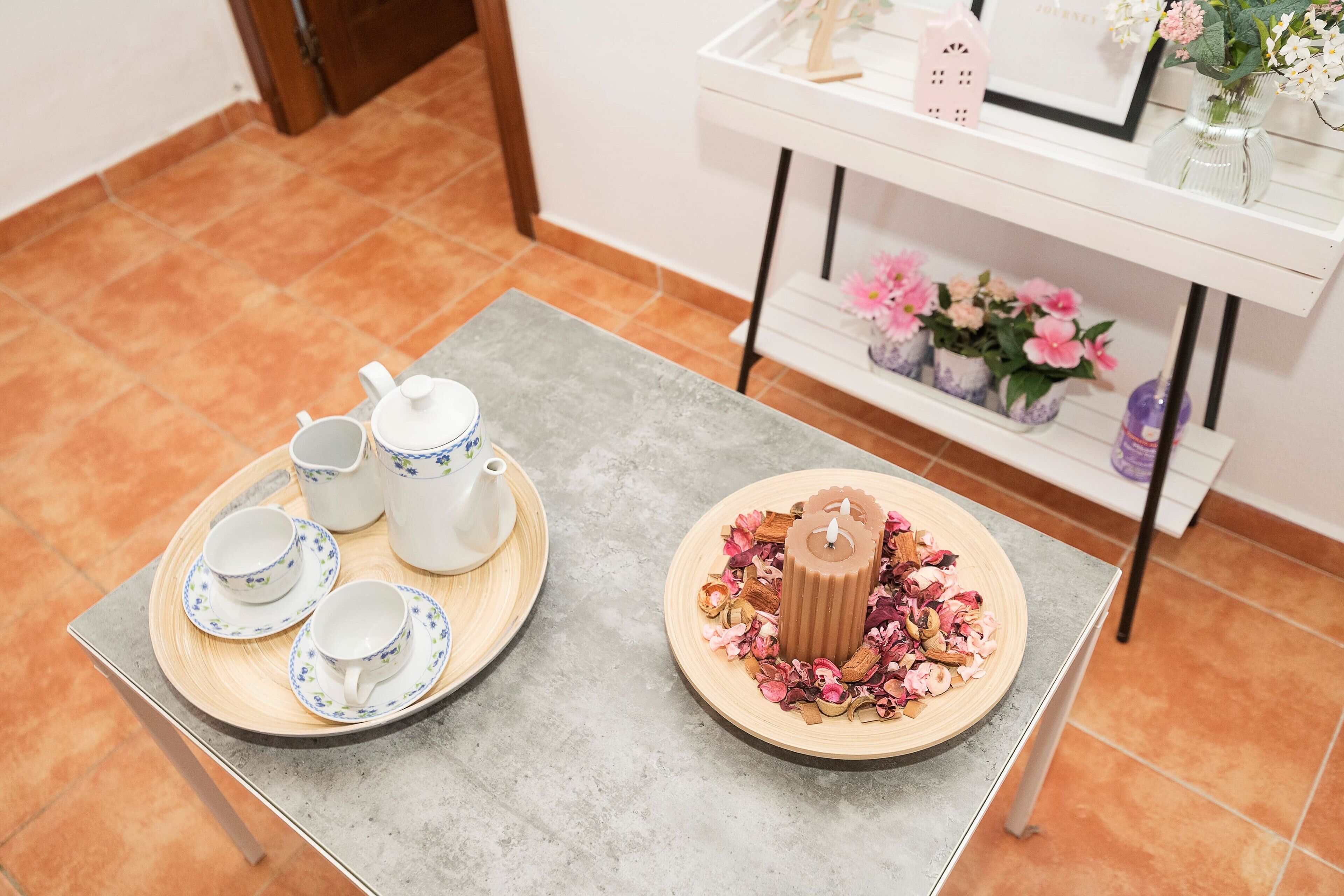A table with a tea set and a candle centerpiece.